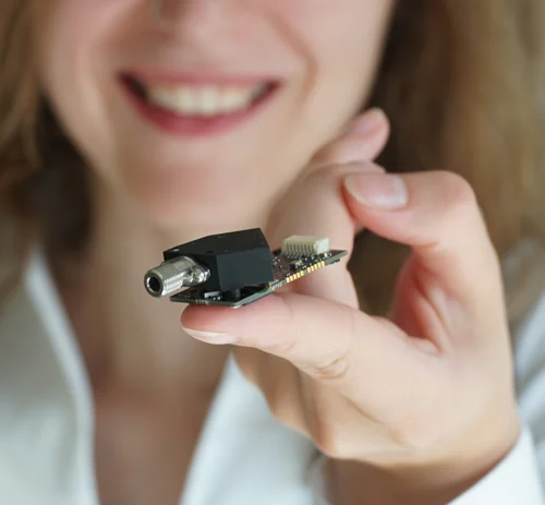 Mitarbeiter hält Mini-Spektrometer mit integriertem Transmissionsgitter